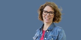 Woman in a denim jacket, glasses and curly hair on blue background