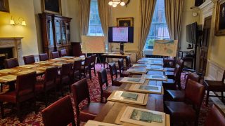 Members' Room in the Royal Irish Academy with two tables and atlases on display. Screen in the background for a presentation