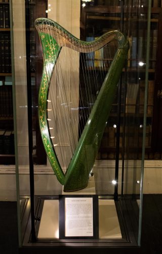 Green harp in a glass case.