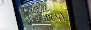 Close-up image of the Royal Irish Academy door sign, focusing on the text and surface, illustrating the sign's significance and style