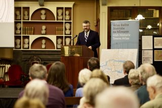 Michael Potterton speaking at a lectern in the meeting room of the Royal Irish Academy