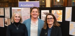 Rachel Murphy, Jennifer Moore and Sarah Gearty posing in front of a display of maps and images in the RIA Meeting Room